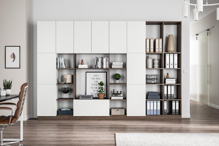 Ein multifunktionaler Wandschrank nach Maß, weiß, mit offenen Regalen für Bücher und Deko, fügt sich in ein modernes Zimmer ein.